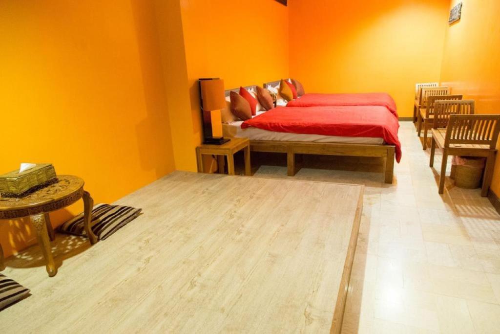 a bedroom with a red bed and yellow walls at Golden Ocean Azure Hotel in Kenting