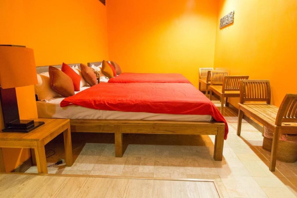 a bedroom with a bed with a red comforter at Golden Ocean Azure Hotel in Kenting