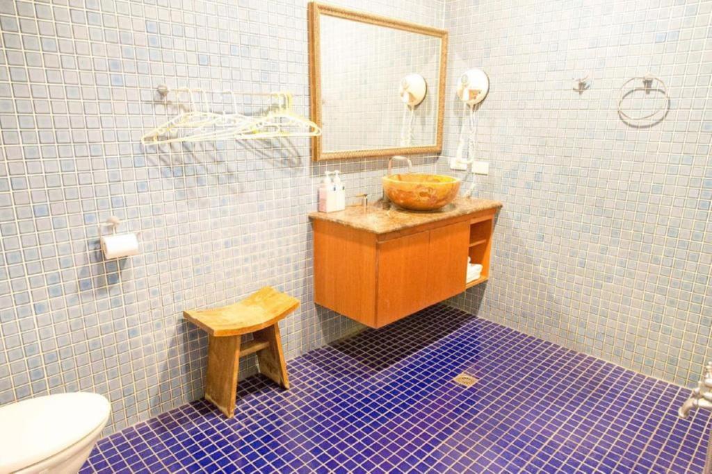 a bathroom with a sink and a mirror and a toilet at Golden Ocean Azure Hotel in Kenting