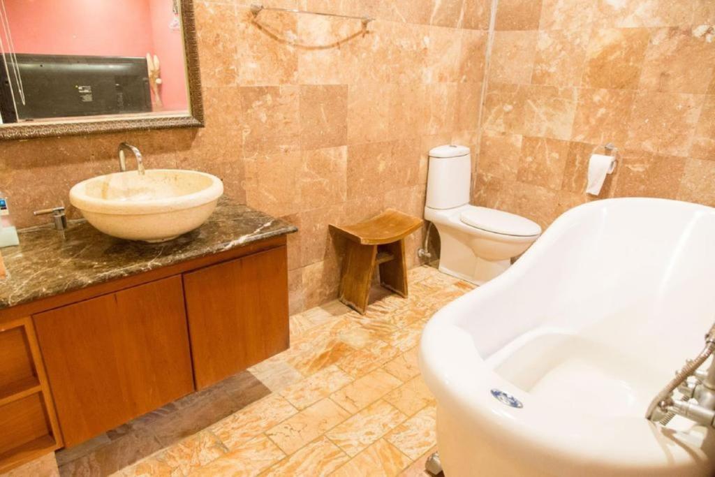 a bathroom with a tub and a sink and a toilet at Golden Ocean Azure Hotel in Kenting