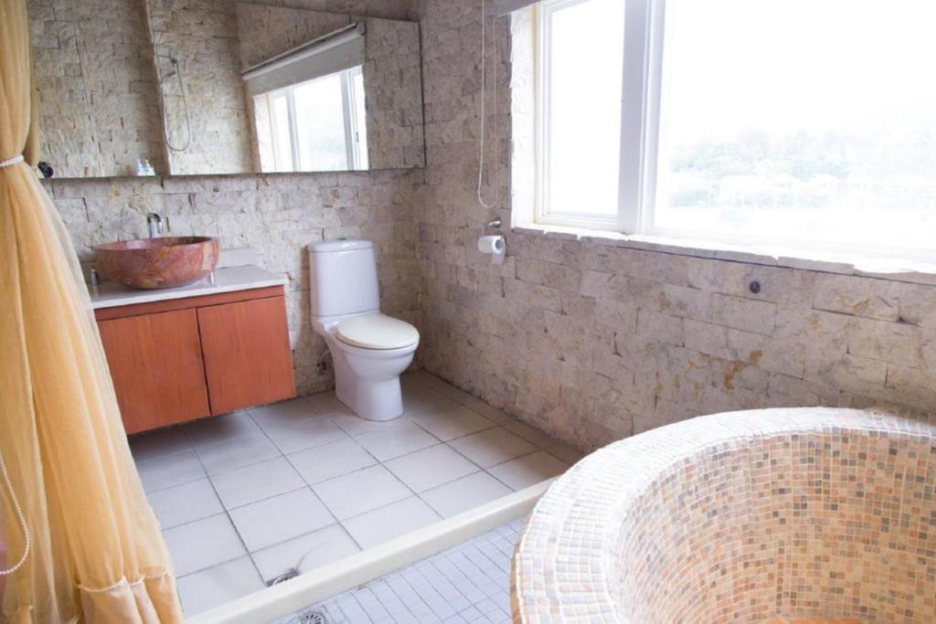 a bathroom with a toilet and a sink and a window at Golden Ocean Azure Hotel in Kenting