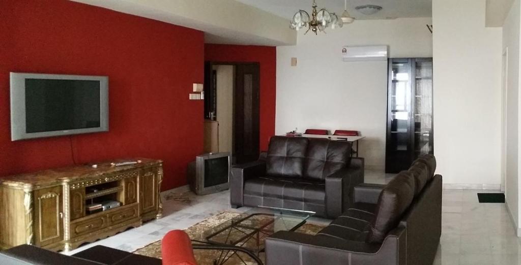 a living room with a couch and a tv at Villa Putra PWTC R3 Single Room in Kuala Lumpur