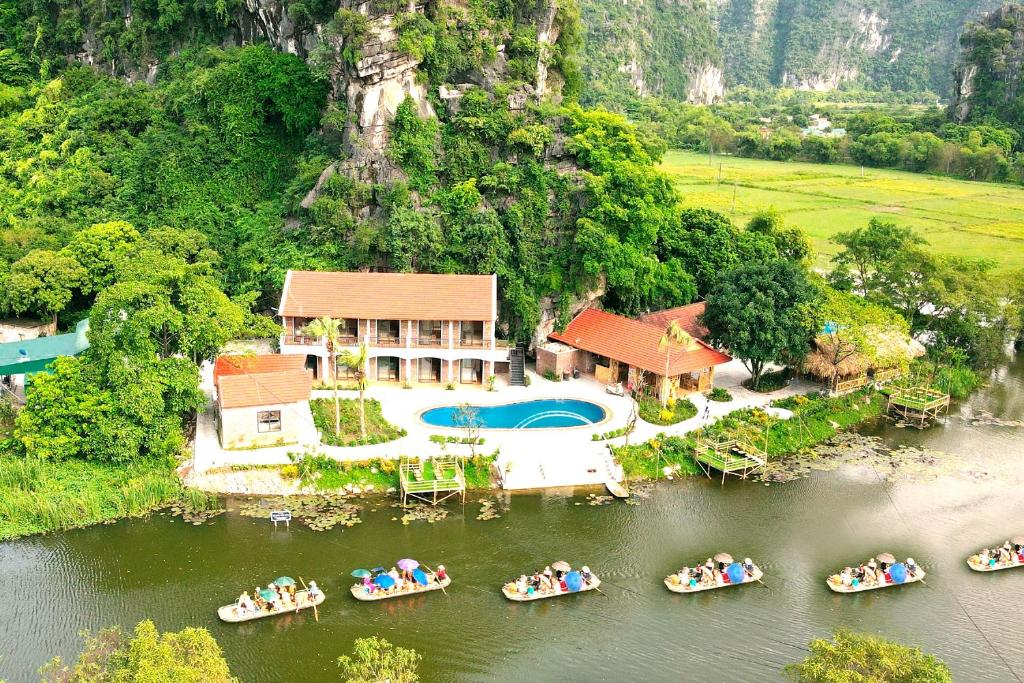 uma vista aérea de uma casa com barcos na água em HoangLong Riverside Homestay em Ninh Binh