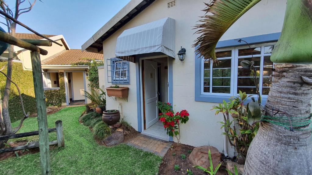 a white house with a palm tree in the yard at The Lazy Lizard in Durban