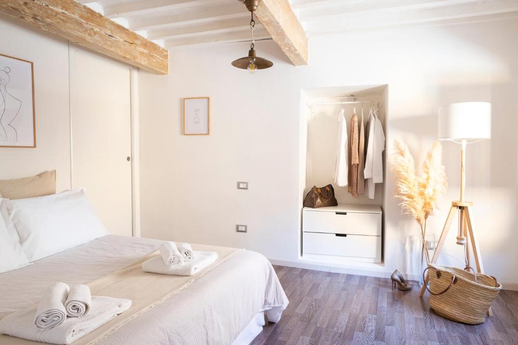 ORANGE Tuscany Flat في سان مينياتو: غرفة نوم بيضاء مع سرير عليه مناشف