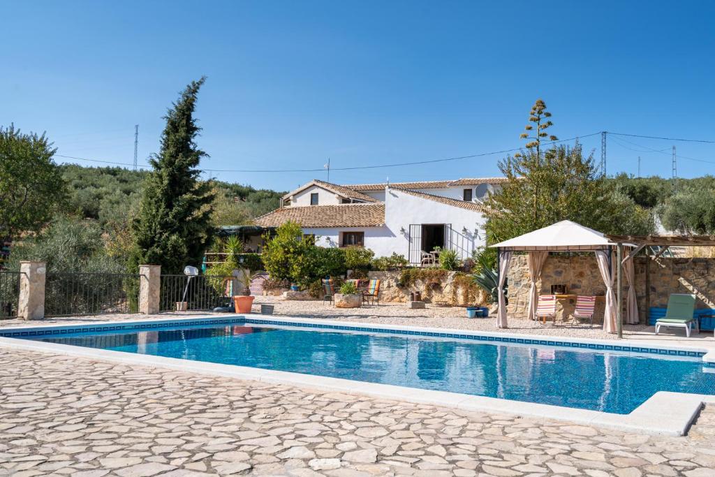 een villa met een zwembad en een huis bij Hacienda la buena vida B&B en appartementen in Algarinejo