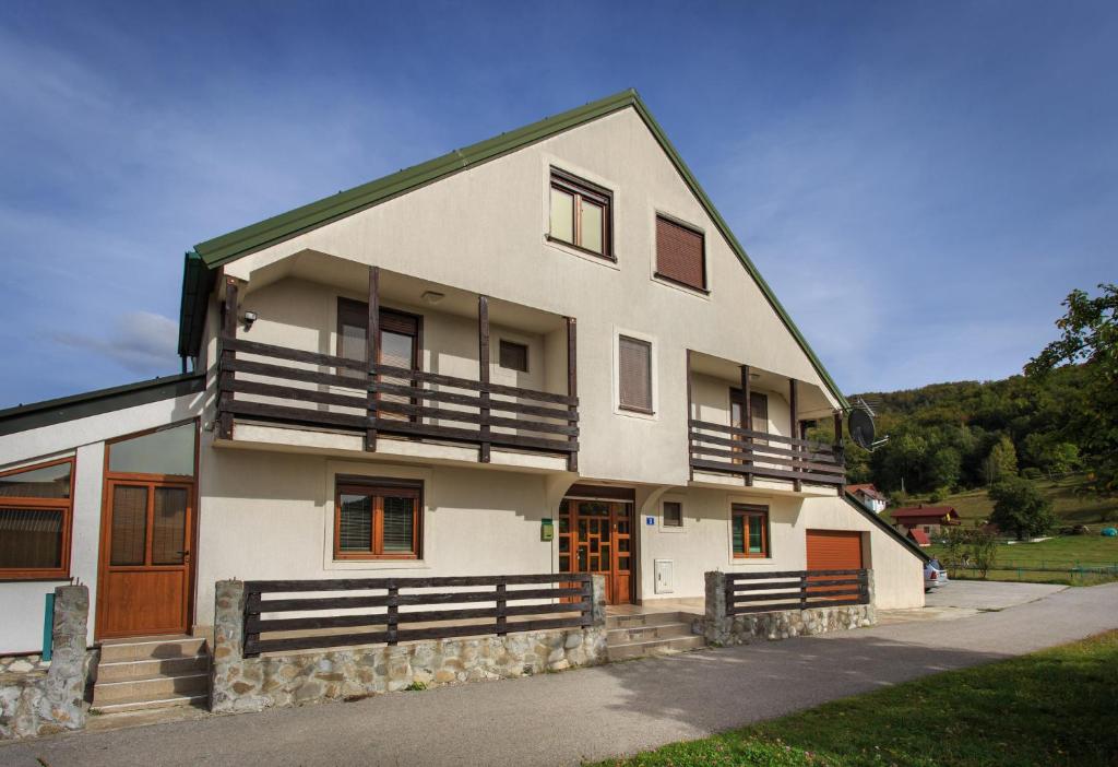 uma grande casa branca com portas e janelas de madeira em Apartments Mery em Kolašin