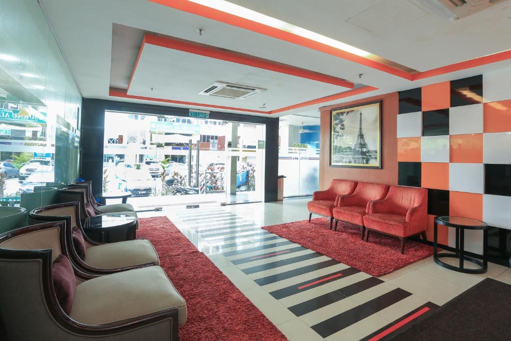 a waiting room with red chairs and a red rug at Super OYO 90101 Gds Hotel Titiwangsa in Kuala Lumpur