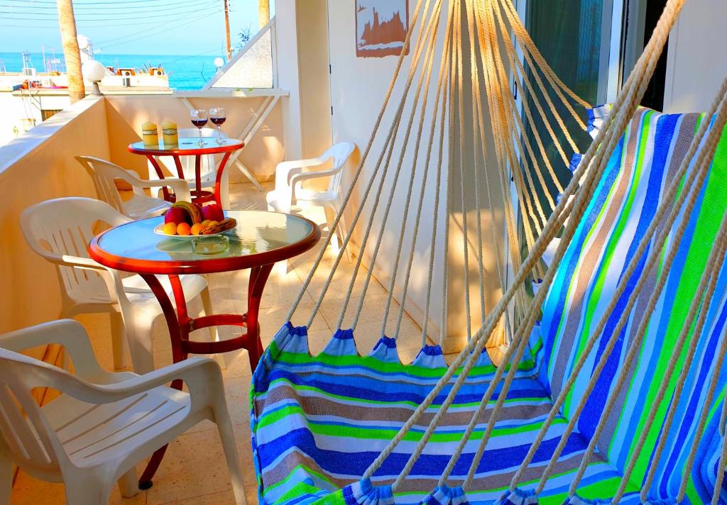 a hammock in a room with a table and chairs at Astrofegia Apartments Near The Sea in Ayia Marina