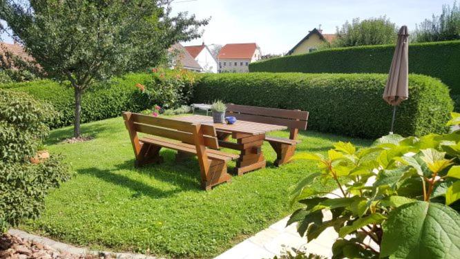 una mesa de picnic y una sombrilla en un jardín en Ferienwohnung Corinna, en Fehring