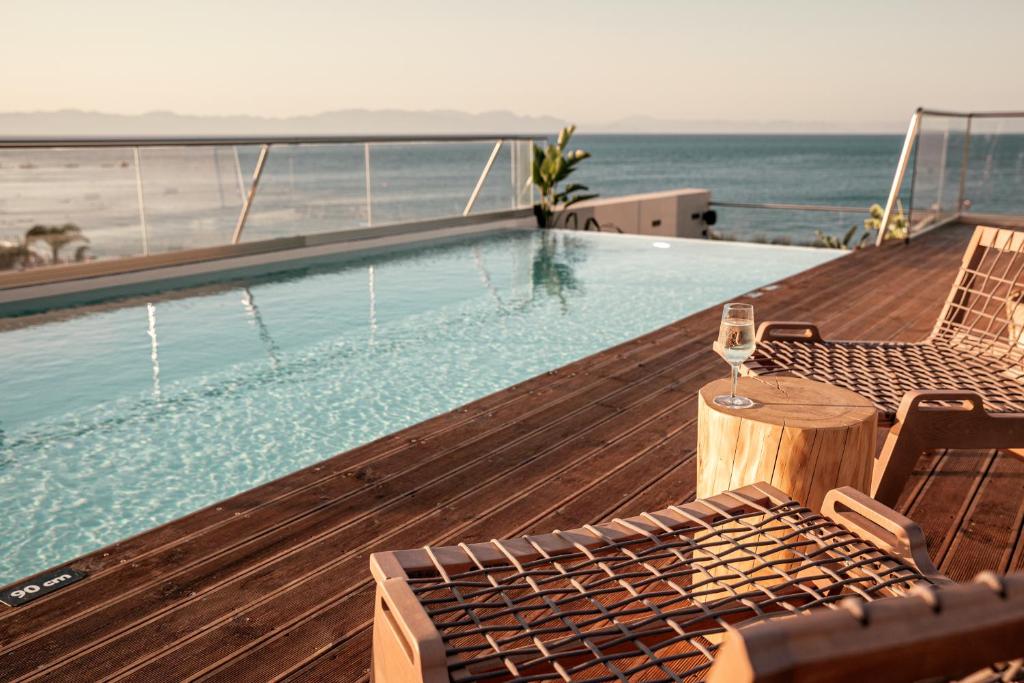 uma piscina com um copo de vinho num deque em Cooks club City Beach Rhodes in Ilha de Rhodes