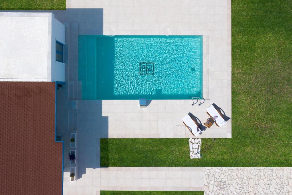 an overhead view of a swimming pool with two chairs at Serenity Villas in Kolimbia
