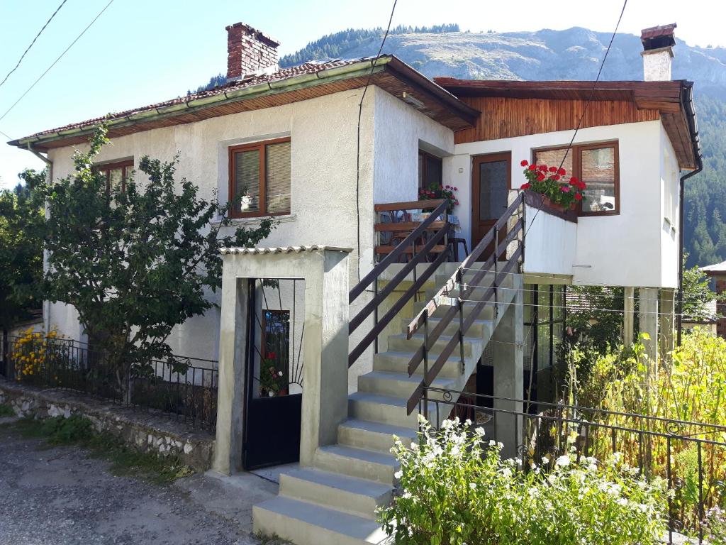 uma pequena casa branca com escadas em frente em Guest house Denitsa em Trigrad