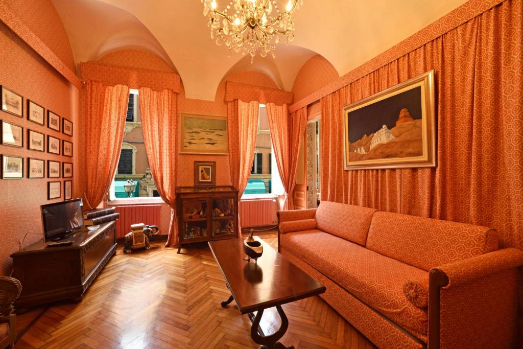 uma sala de estar com cortinas cor de laranja e um sofá em Casa d'artista B&B em Alassio