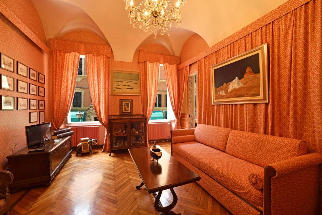 sala de estar con cortinas de color naranja y sofá en Casa d'artista B&B en Alassio