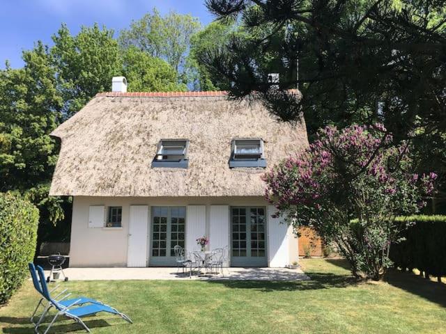 een klein wit huis met een rieten dak bij Le Lodge des Prés in Eu