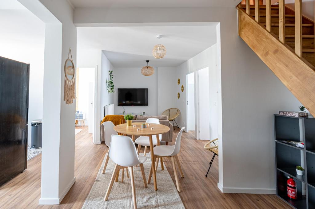 - une salle à manger et un salon avec une table et des chaises dans l'établissement Le Grand Drancy - 3 chambres - tout équipé, à Drancy