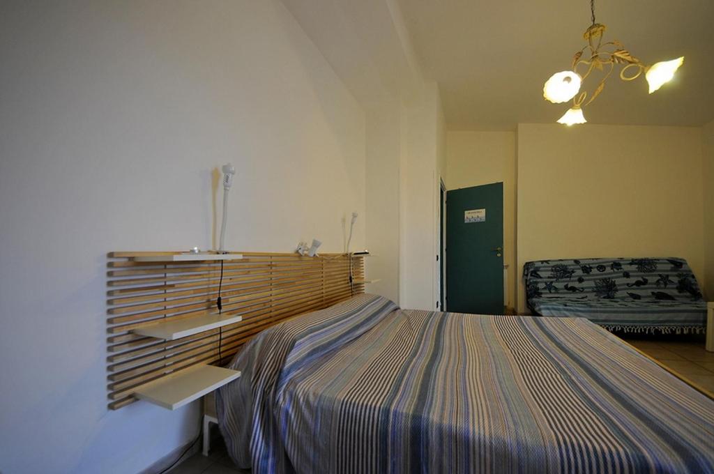 Łóżko lub łóżka w pokoju w obiekcie A La vue chambre BAGNO CONDIVISO SHARED BOTH2piano no lift no navetta a pagamento aria condizionata ed extra bed 3 MINUTI A PIEDI DA BUS PER FIERA DI ROMA