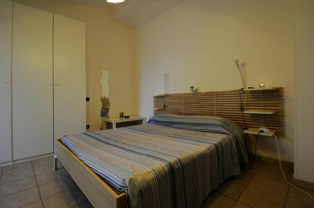sypialnia z dużym łóżkiem z drewnianym zagłówkiem w obiekcie A La vue chambre BAGNO CONDIVISO SHARED BOTH2piano no lift no navetta a pagamento aria condizionata ed extra bed 3 MINUTI A PIEDI DA BUS PER FIERA DI ROMA w mieście Fiumicino