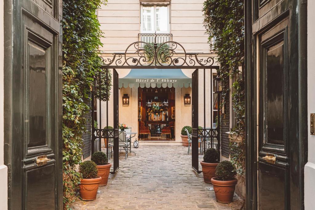 um arco que conduz a um edifício com vasos de plantas em Hôtel de l'Abbaye em Paris