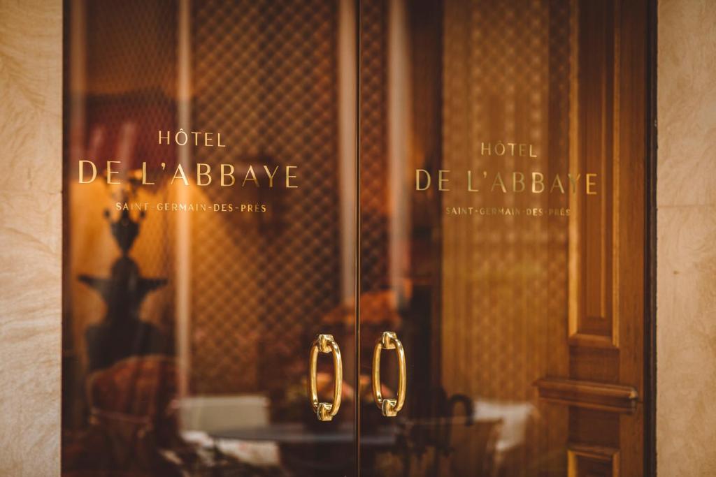 a glass door with two handles in a room at Hôtel de l&#39;Abbaye in Paris