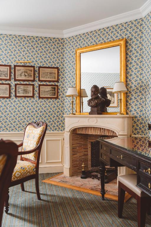 a living room with a fireplace and a mirror at Hôtel de l&#39;Abbaye in Paris