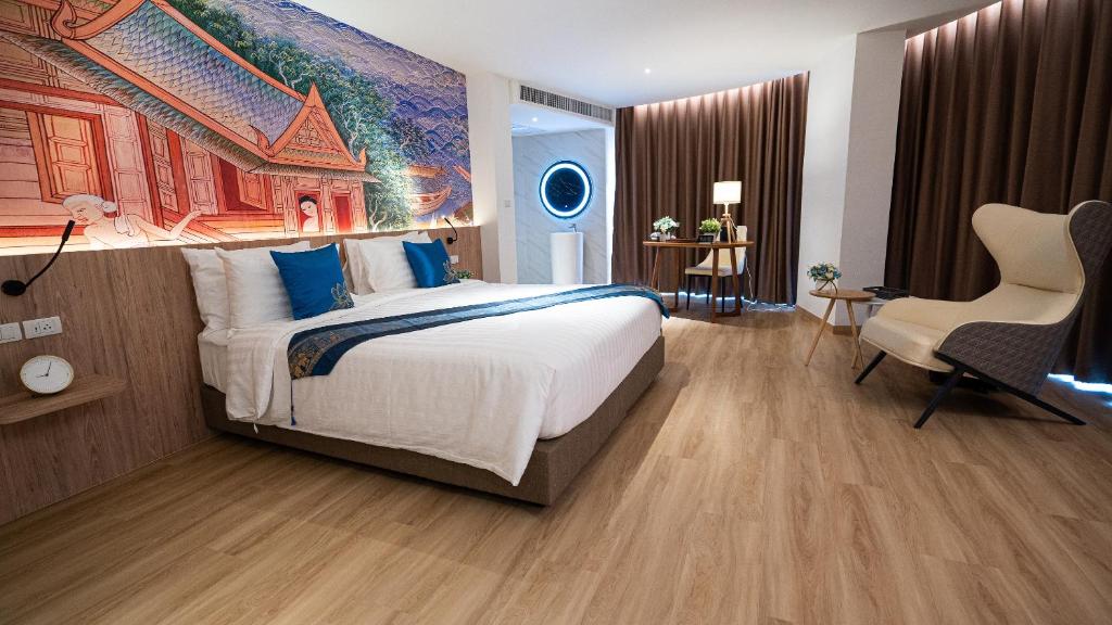 ein Schlafzimmer mit einem großen Bett und einem Gemälde an der Wand in der Unterkunft Pannarai Hotel Bangkok in Bangkok
