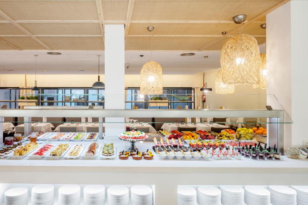 a buffet of food on display in a restaurant at AQUA Hotel Bertran Park in Lloret de Mar