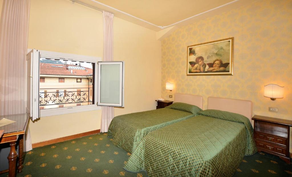 Postel nebo postele na pokoji v ubytování Grand Hotel Plaza & Locanda Maggiore