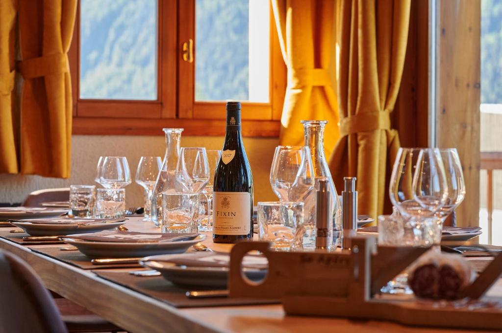a table with glasses and a bottle of wine on it at Chalet ALPACA Peisey-Vallandry - Domaine Paradiski in Peisey-Nancroix
