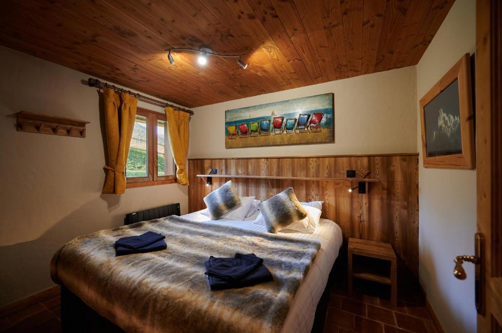a bedroom with a bed with two towels on it at Chalet ALPACA Peisey-Vallandry - Domaine Paradiski in Peisey-Nancroix