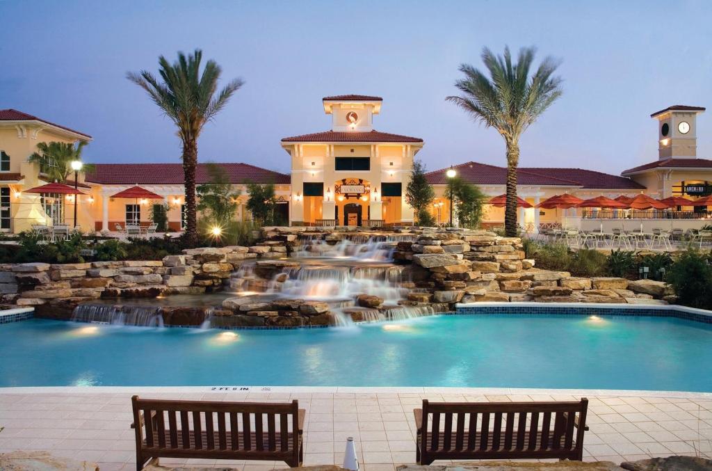 uma piscina de resort com uma cascata e dois bancos em Holiday Inn Club Vacations At Orange Lake Resort, an IHG Hotel em Orlando