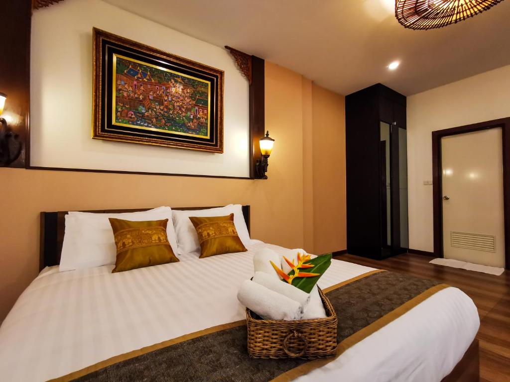 a bedroom with a large white bed with a chair at QG Resort in Lat Krabang