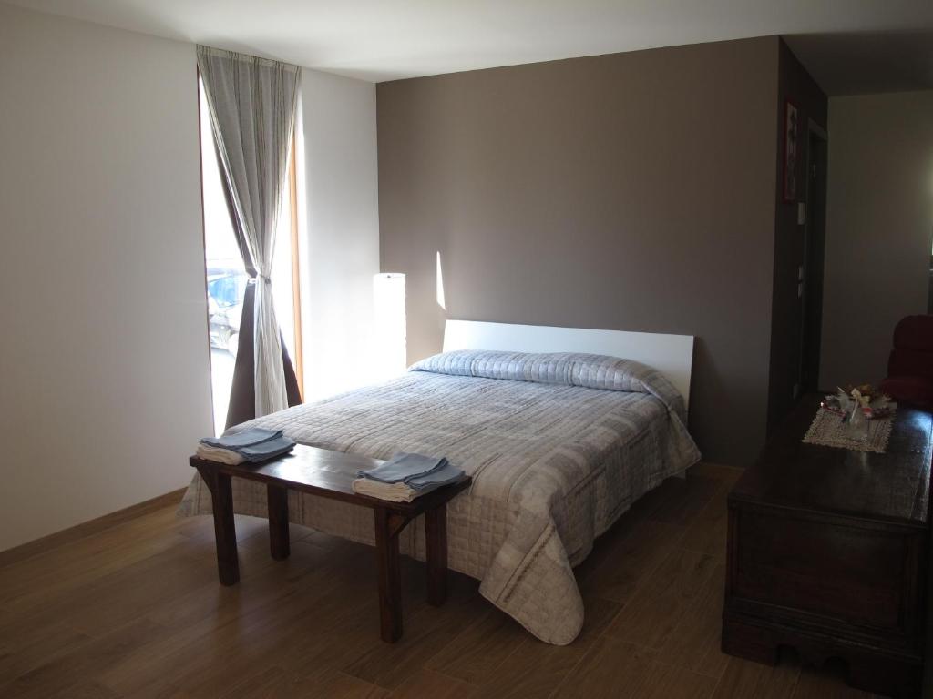 um quarto com uma cama com uma mesa e uma janela em B&B Baratoff em Pesaro