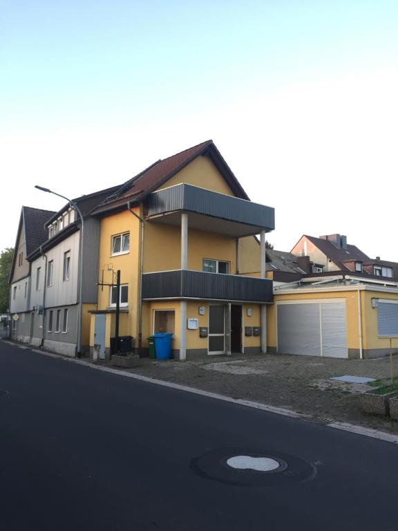una casa amarilla al lado de una calle en Neo Event Hall room Neo2, en Staufenberg