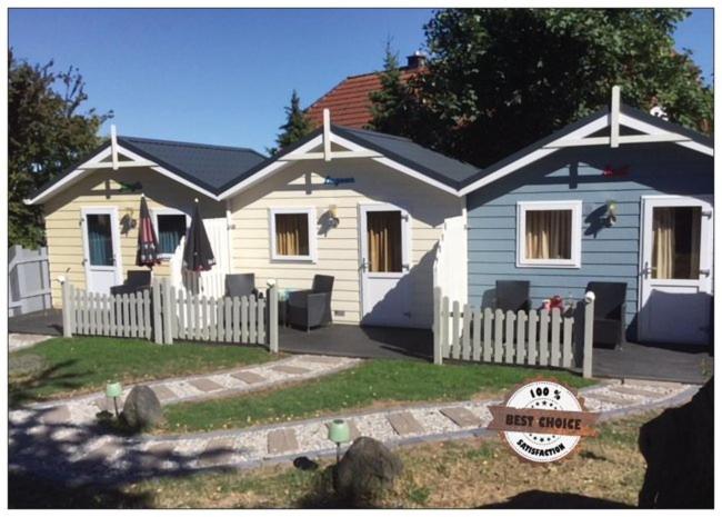 a small white house with a white picket fence at zu Jeddelohs Bungalows & Apartments -Adult friendly in Gladenbach