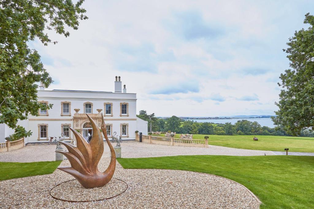 a metal sculpture in front of a white house at Lympstone Manor Hotel in Exmouth