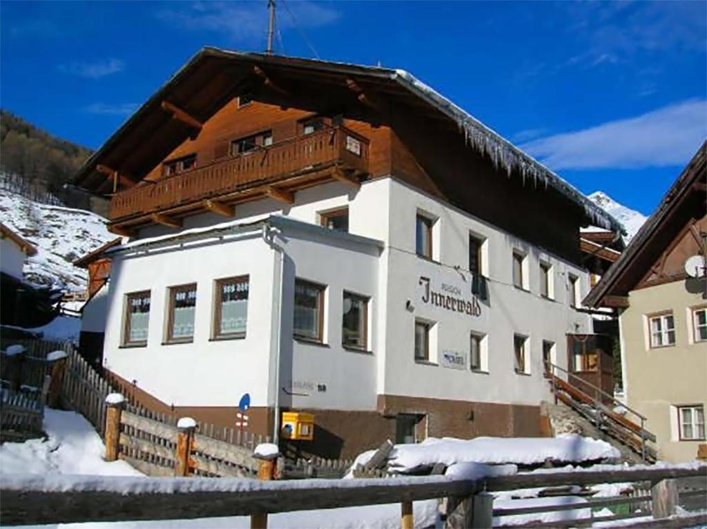 een groot gebouw met een houten dak in de sneeuw bij Haus Innerwald by Châtel Reizen in Sölden