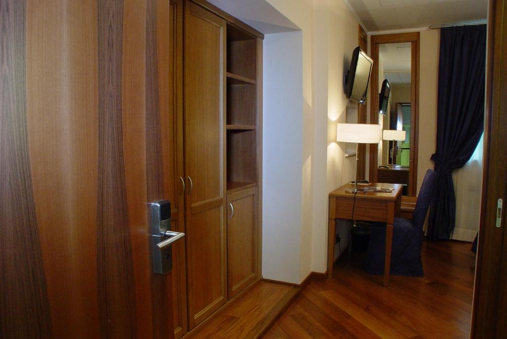 a room with a door and a table and a lamp at Hotel Iris in Genoa