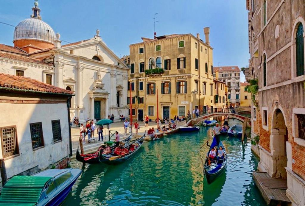 un groupe de gondoles dans un canal d'une ville dans l'établissement CA CICOGNA air conditioning and fast WiFi, central location apartment, à Venise
