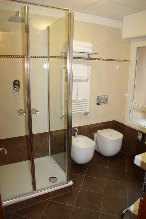 a bathroom with a shower and a toilet and a sink at Hotel Iris in Genoa