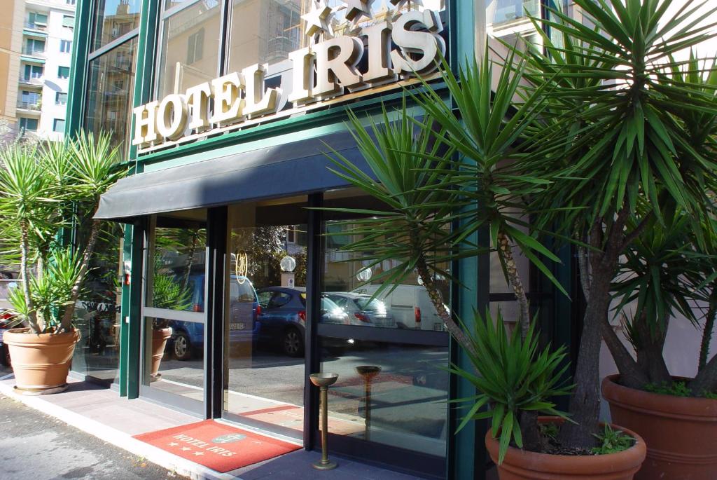 a hotel entrance with palm trees in front of it at Hotel Iris in Genoa