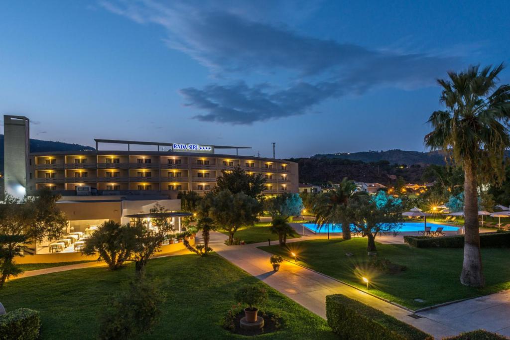 un hôtel avec une piscine et des palmiers la nuit dans l'établissement Rada Siri, à Montepaone