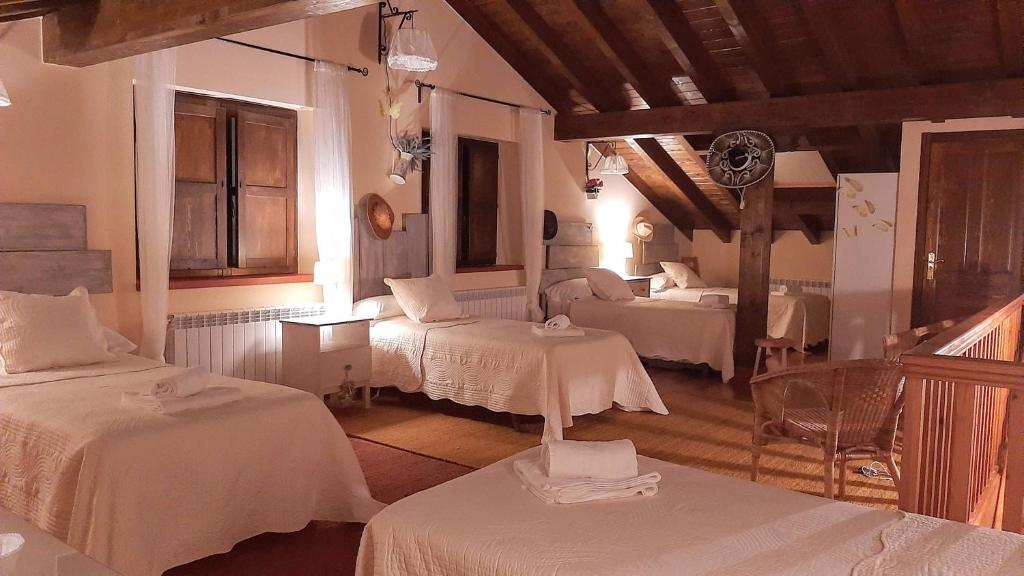 a room with two beds and two tables in it at Apartamentos San Antonio de Garabandal in San Sebastián de Garabandal