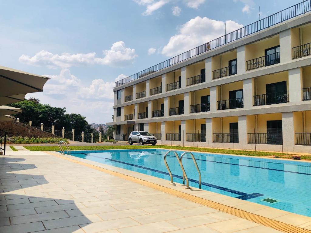 a hotel with a swimming pool in front of a building at Phoenix Apartment by LINK in Kigali