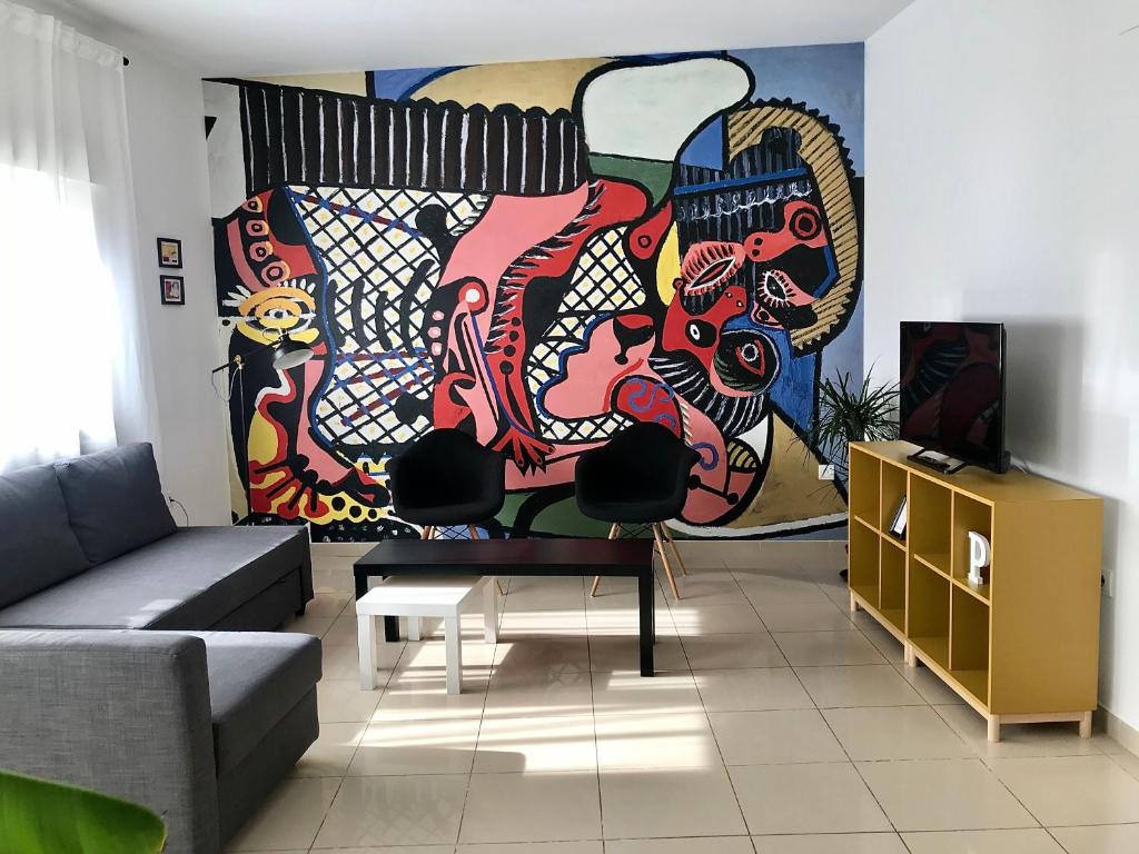 ein Wohnzimmer mit einem Sofa und einem Gemälde an der Wand in der Unterkunft Apartamentos Élite - Art Collection - Pablo in Merida