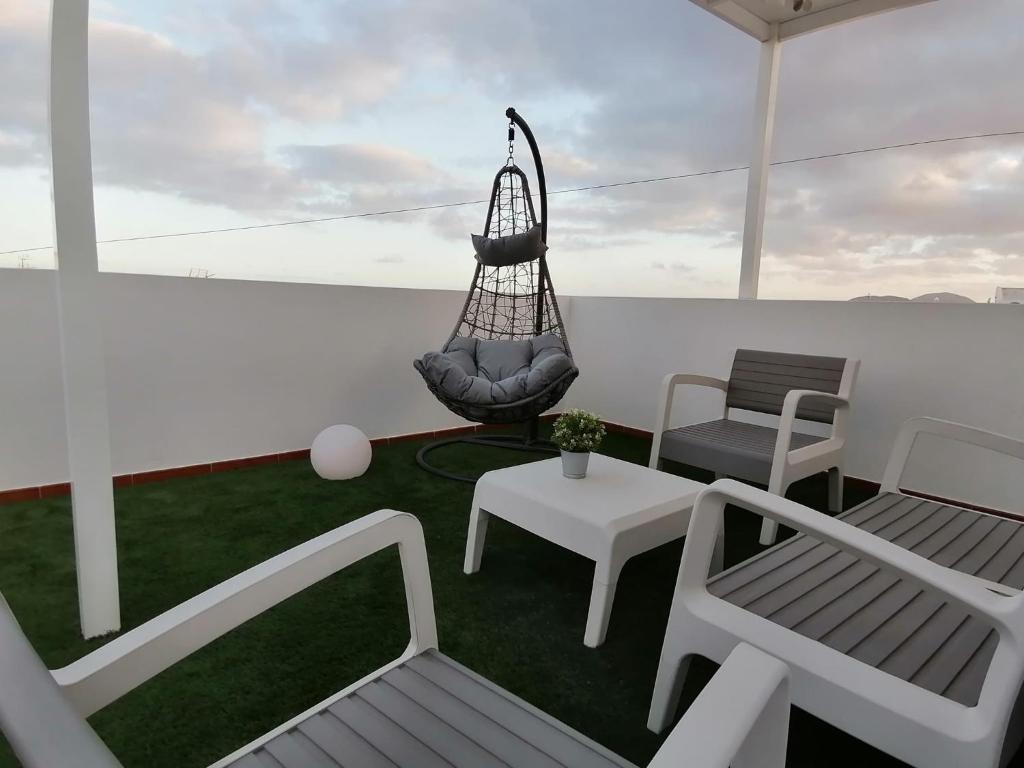 un balcón con un columpio y sillas en un barco en Casa Alvaria en Punta de Mujeres