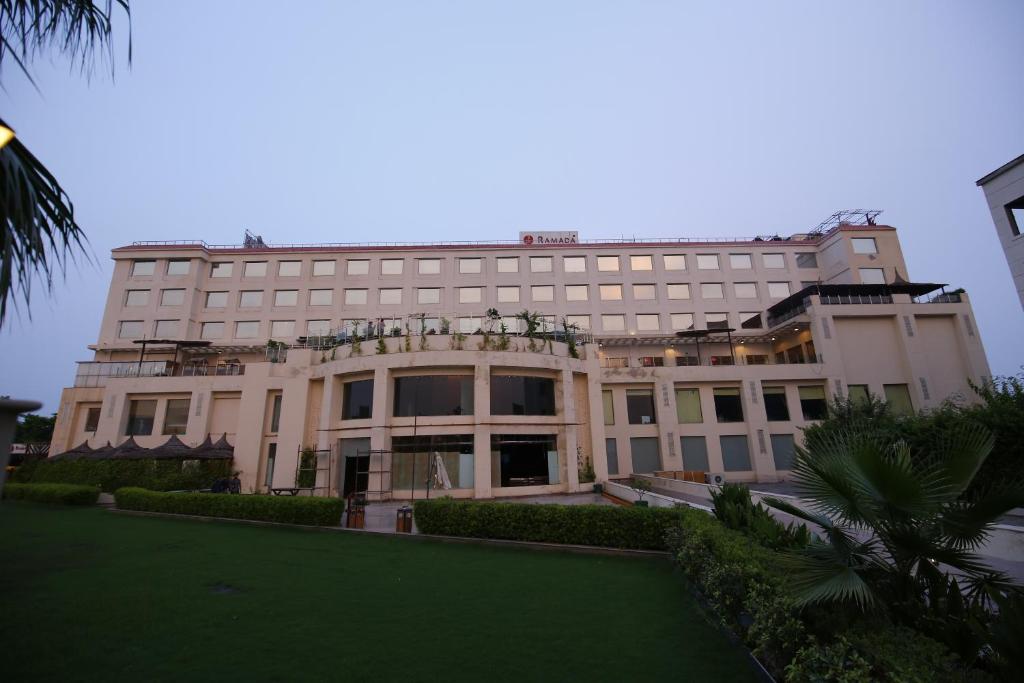尼玛纳内姆拉纳华美达酒店的一座前面有绿色草坪的建筑