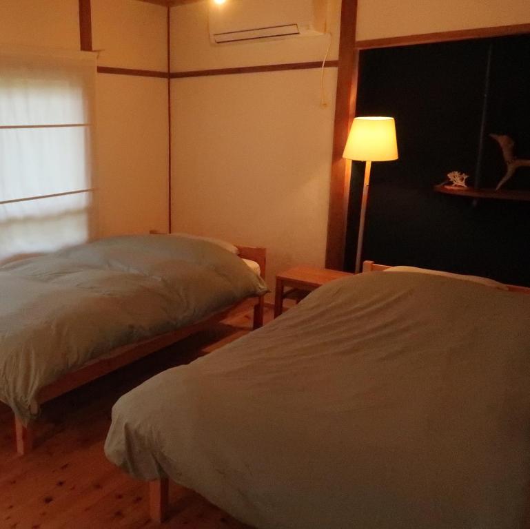 Postel nebo postele na pokoji v ubytování 奈多みどり荘 Nada Beach House