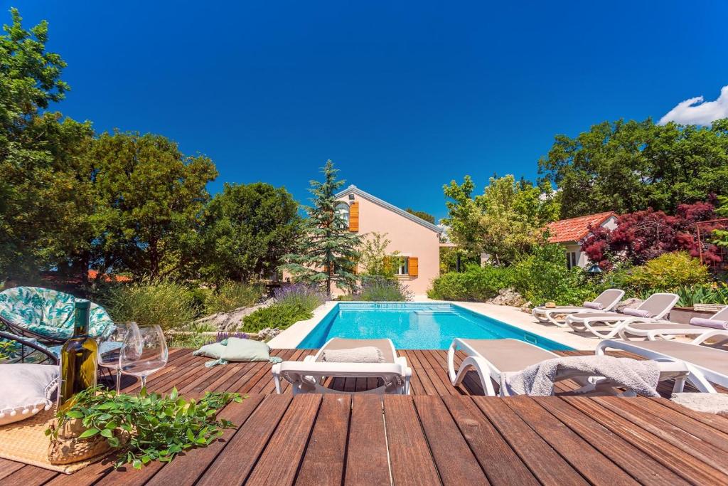a swimming pool with chaise lounge chairs next to a house at Villa Tajina Kuca in Žeževica